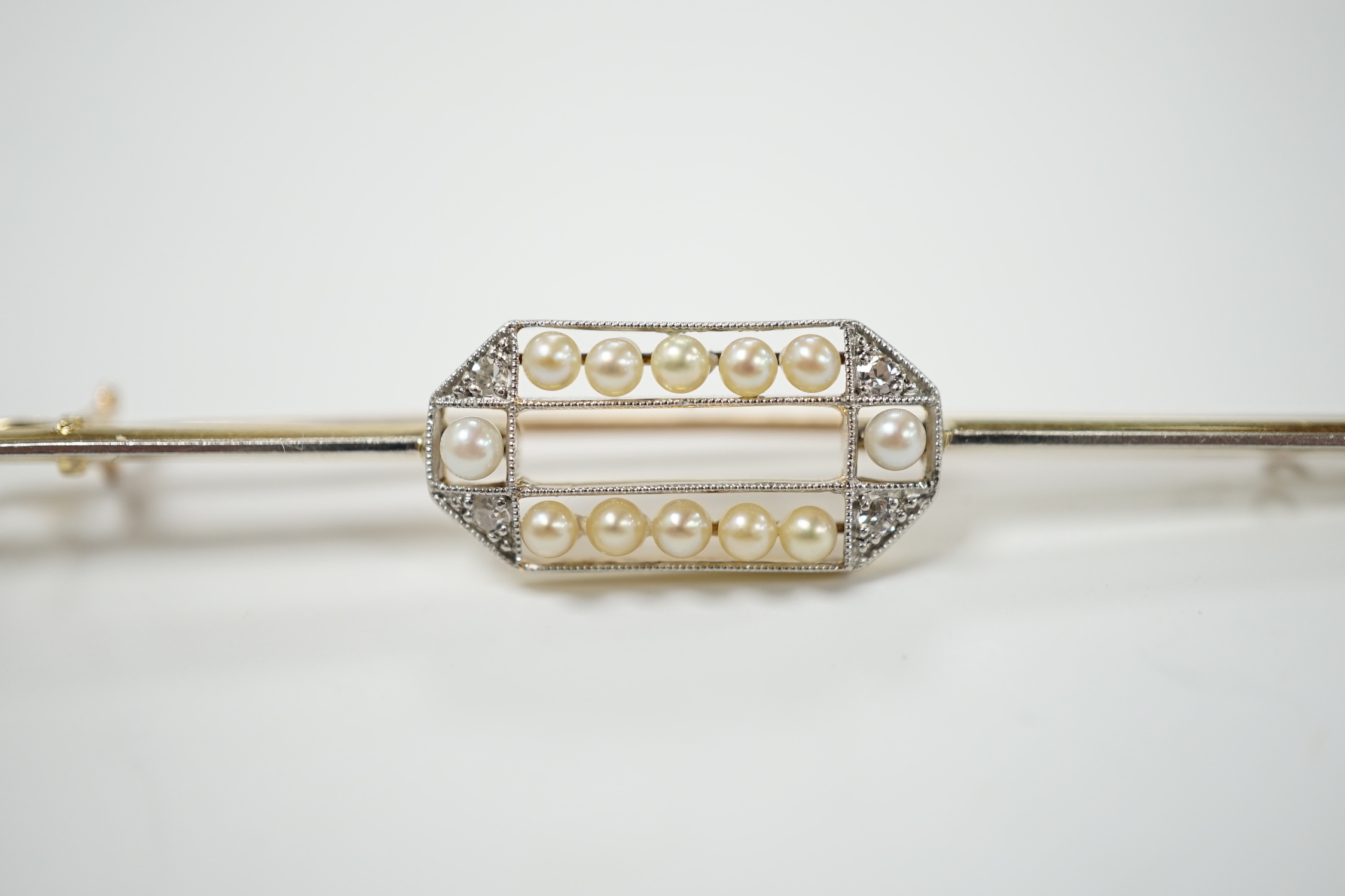 A Belle Epoque 15ct, diamond and seed pearl set bar brooch, 63mm, gross weight 3.9 grams.